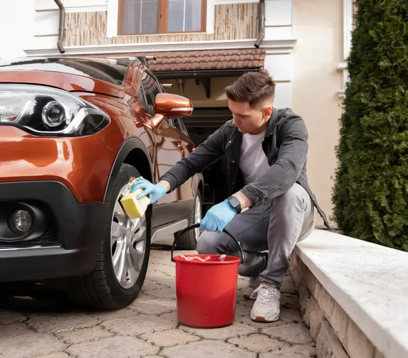 Lavage auto à domicile Villeneuve-la-Comtesse : professionnel intervenant sur un véhicule